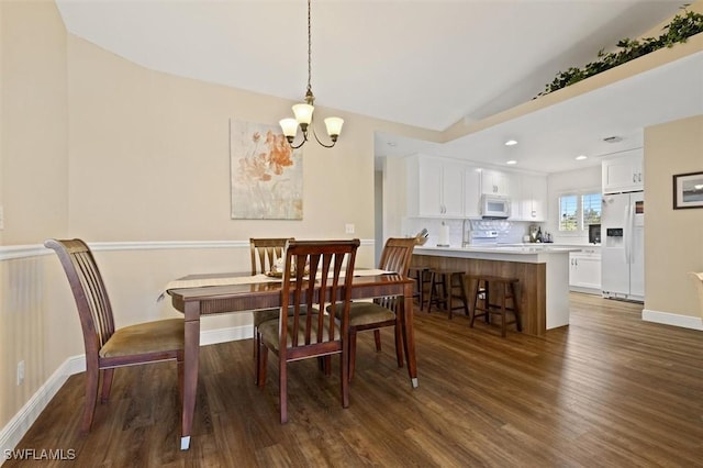 dining room featuring baseboards, wood finished floors, an inviting chandelier, vaulted ceiling, and recessed lighting