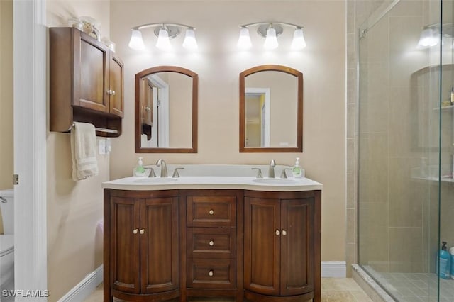 bathroom with a stall shower, a sink, toilet, and double vanity