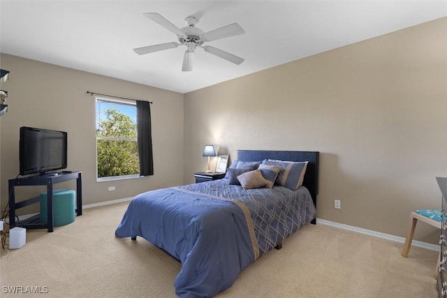 carpeted bedroom with ceiling fan and baseboards