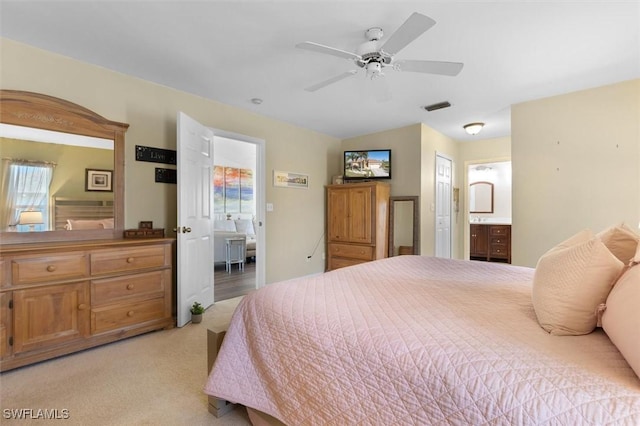 bedroom featuring ceiling fan, visible vents, connected bathroom, and light colored carpet