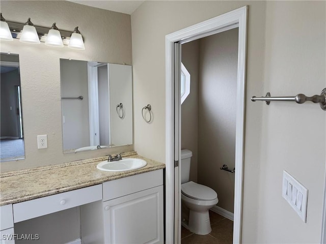 bathroom featuring toilet, tile patterned flooring, and vanity