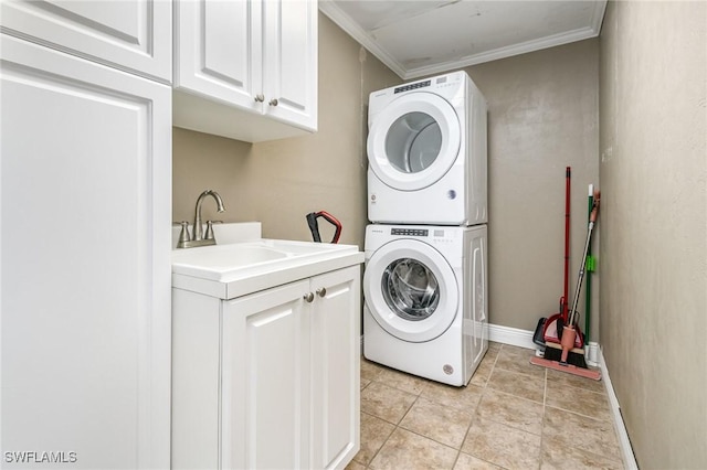 laundry area featuring light tile patterned floors, stacked washer / drying machine, cabinet space, ornamental molding, and a sink