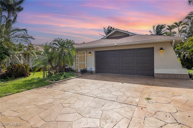 ranch-style home with a garage, concrete driveway, and stucco siding