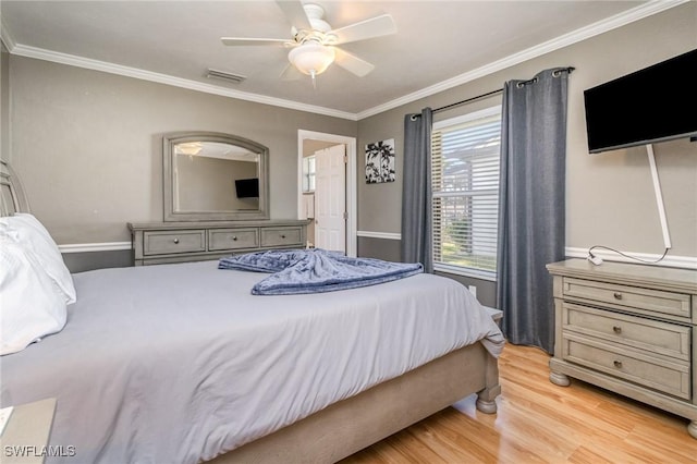 bedroom featuring ceiling fan, ornamental molding, light wood-type flooring, and visible vents