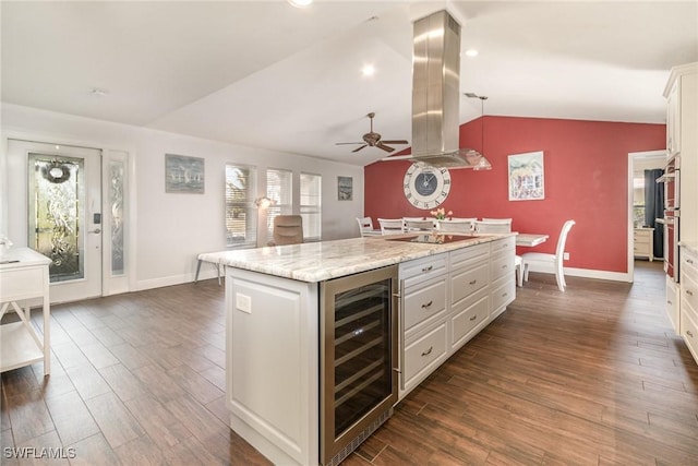 kitchen featuring a kitchen island, wine cooler, decorative light fixtures, island exhaust hood, and white cabinetry