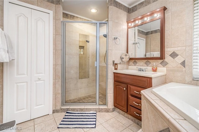 bathroom featuring a stall shower, tile patterned floors, tile walls, and vanity