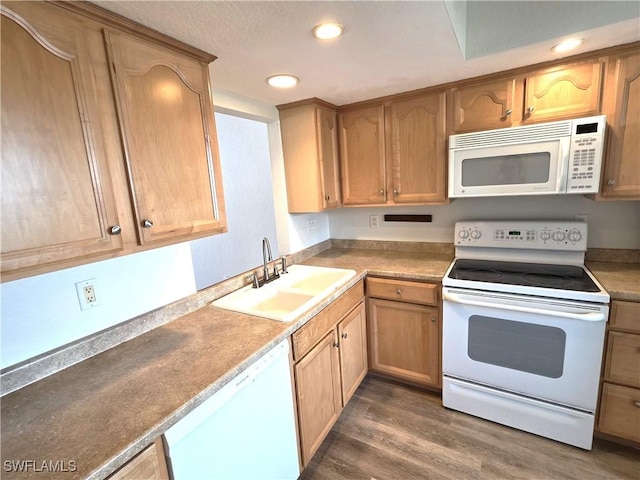 kitchen featuring recessed lighting, white appliances, a sink, dark wood-style floors, and brown cabinetry