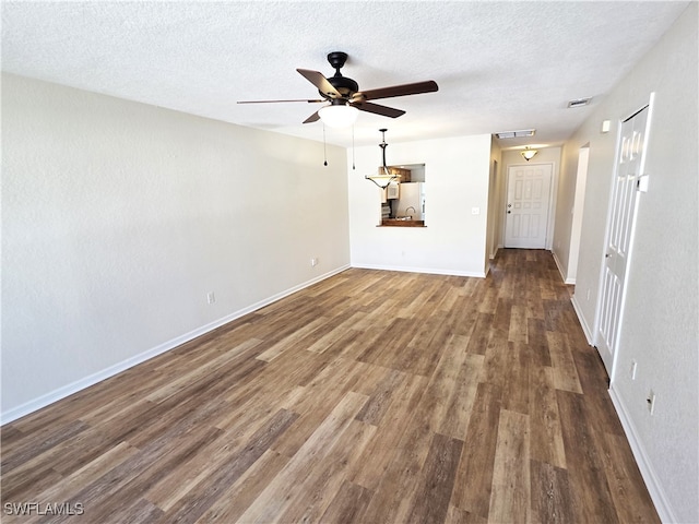 spare room featuring attic access, baseboards, visible vents, dark wood-type flooring, and a textured ceiling