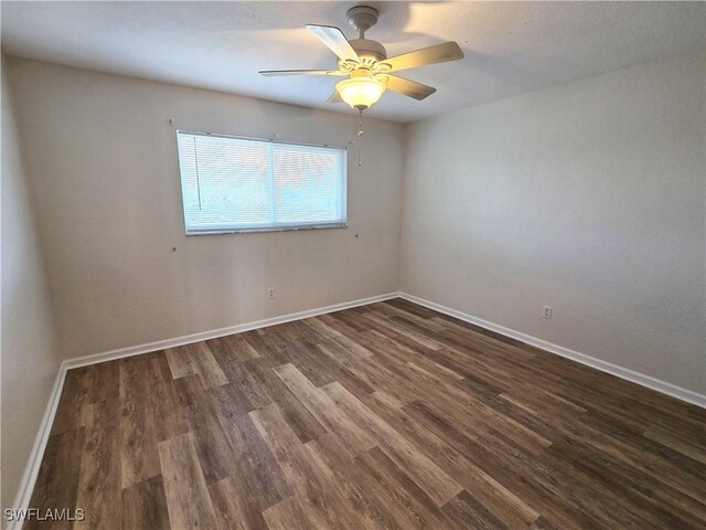 spare room featuring dark wood-style floors, ceiling fan, and baseboards