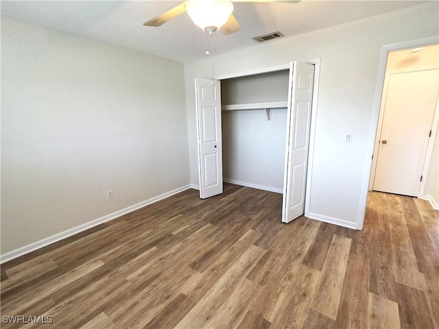 unfurnished bedroom featuring a closet, visible vents, baseboards, and wood finished floors