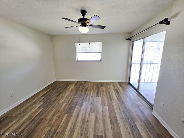 unfurnished room with a healthy amount of sunlight, dark wood-style floors, baseboards, and a textured ceiling