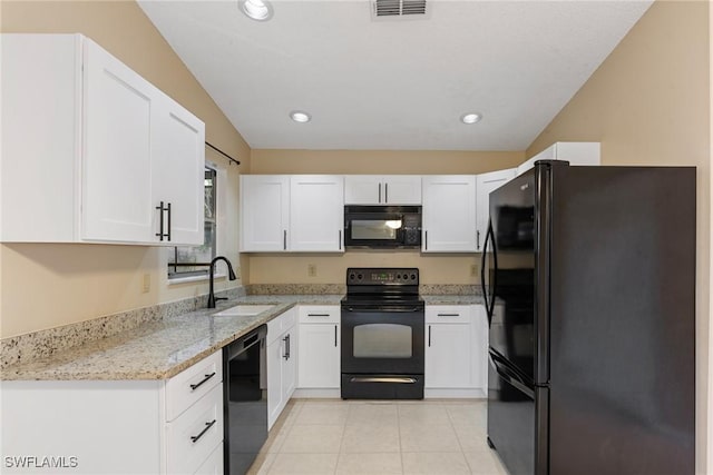 kitchen featuring a sink, visible vents, black appliances, and white cabinetry