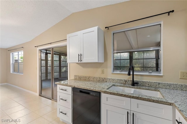 kitchen with light tile patterned flooring, a sink, vaulted ceiling, white cabinets, and dishwasher