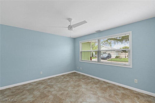 empty room with visible vents, baseboards, and a ceiling fan