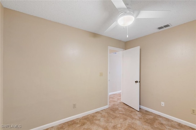 spare room featuring visible vents, ceiling fan, a textured ceiling, and baseboards