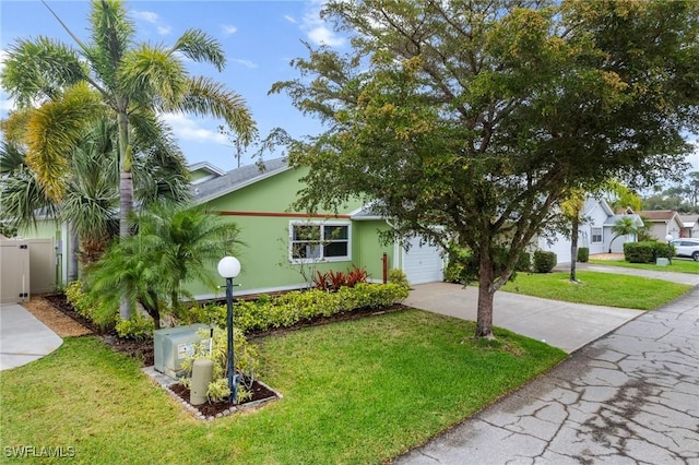 view of front of home featuring a front yard, an attached garage, driveway, and stucco siding