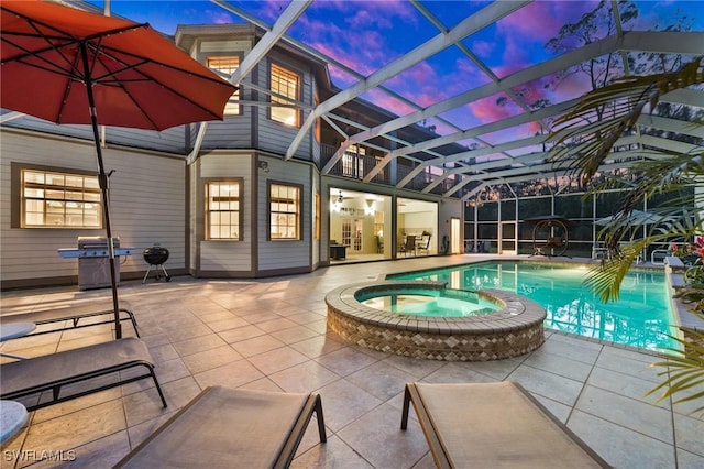 pool at dusk with a lanai, a pool with connected hot tub, area for grilling, and a patio