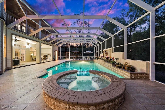 view of pool with a patio area, glass enclosure, a pool with connected hot tub, and ceiling fan