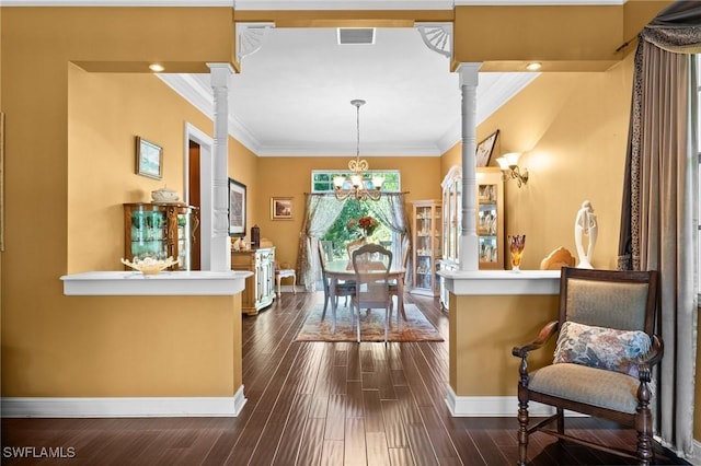 interior space featuring ornate columns, ornamental molding, and dark wood finished floors