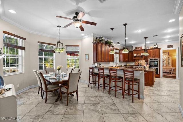 dining space with light tile patterned flooring, crown molding, baseboards, and ceiling fan