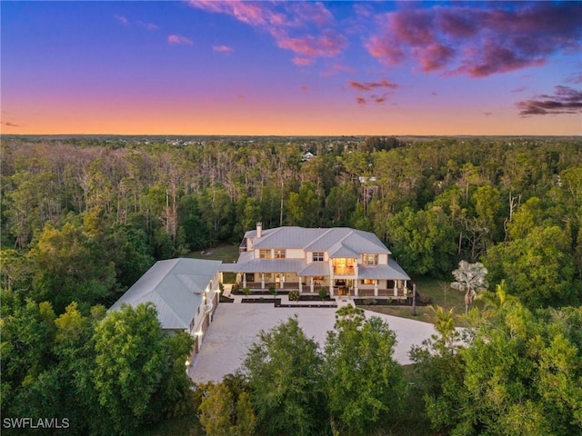 aerial view at dusk featuring a view of trees