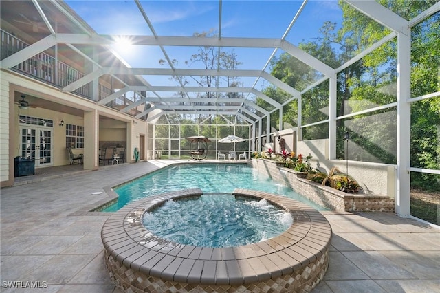 view of pool featuring a patio area, glass enclosure, and a pool with connected hot tub