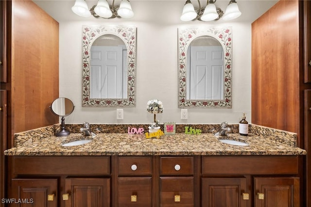 bathroom featuring a sink, an inviting chandelier, and double vanity