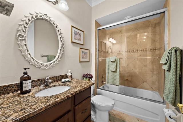 bathroom with toilet, bath / shower combo with glass door, and vanity