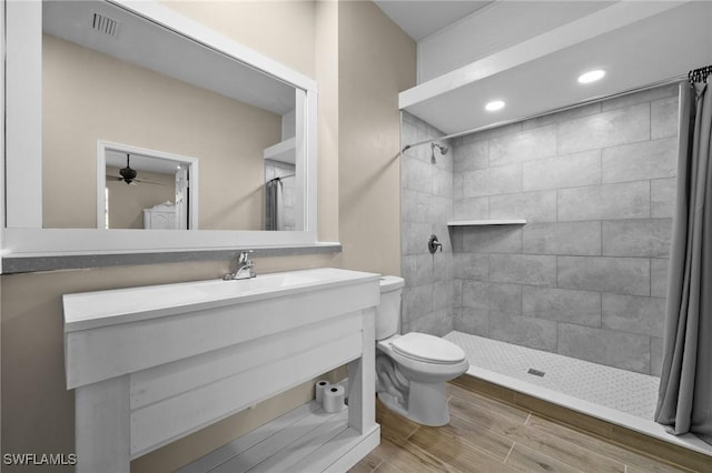 full bathroom featuring toilet, a stall shower, wood finished floors, and vanity