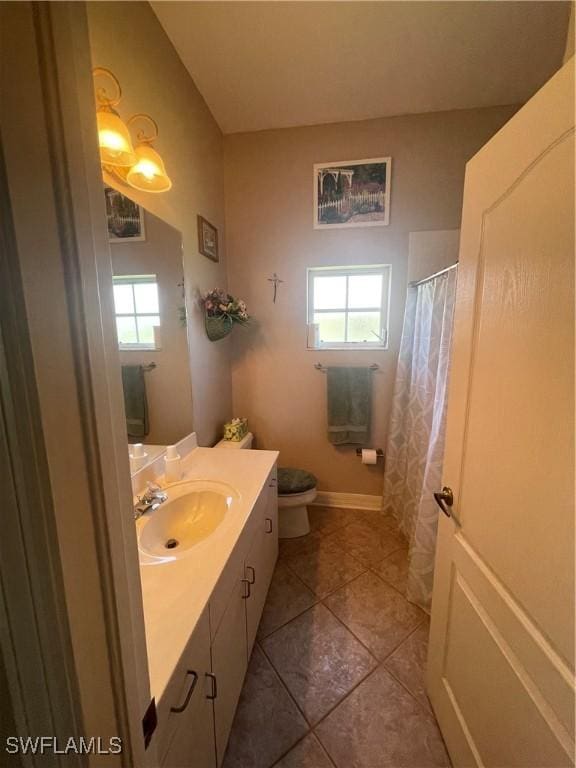 bathroom featuring toilet, baseboards, vanity, and tile patterned floors