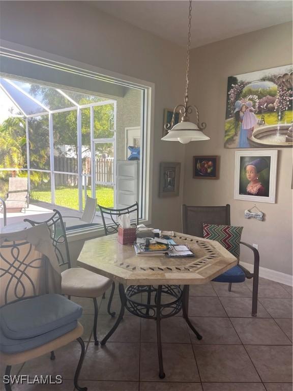 dining space featuring baseboards, a sunroom, and tile patterned floors