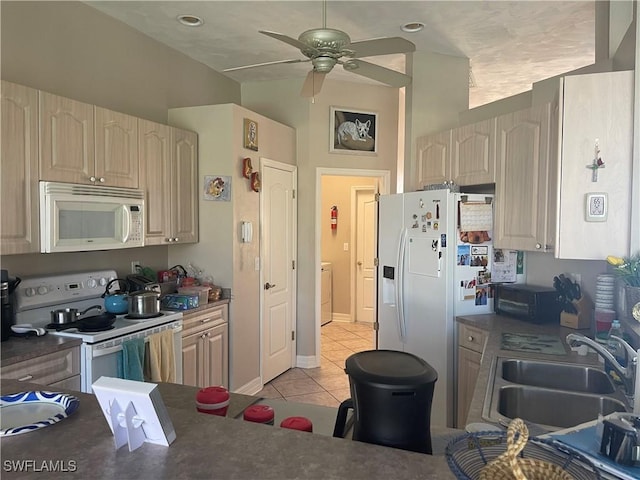 kitchen with ceiling fan, light tile patterned flooring, white appliances, a sink, and dark countertops