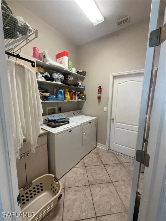 laundry area with laundry area, light tile patterned floors, baseboards, visible vents, and independent washer and dryer