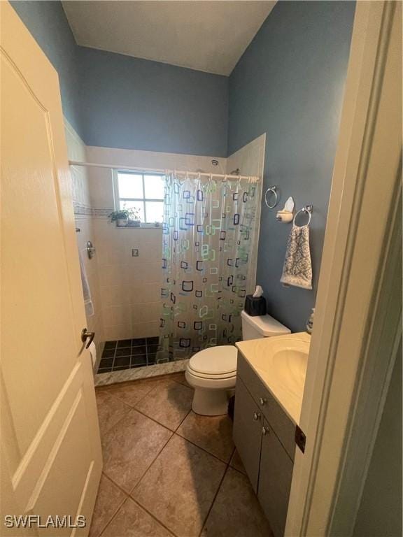 bathroom featuring vanity, a shower stall, toilet, and tile patterned floors