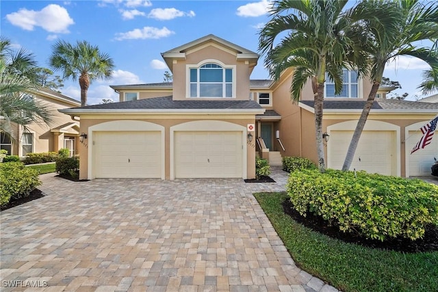 view of front of house with decorative driveway and stucco siding