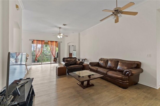 living room with ornamental molding, visible vents, and light wood-style flooring