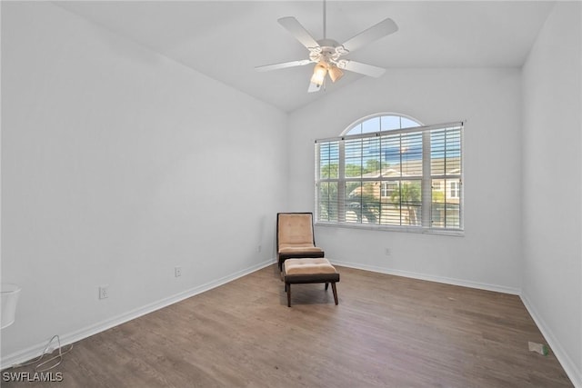 living area featuring ceiling fan, baseboards, vaulted ceiling, and wood finished floors