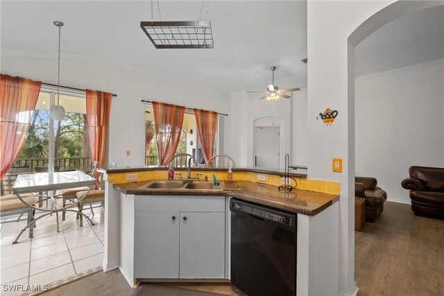 kitchen featuring arched walkways, a peninsula, white cabinetry, dishwasher, and pendant lighting