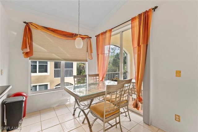 dining space with light tile patterned floors and ornamental molding