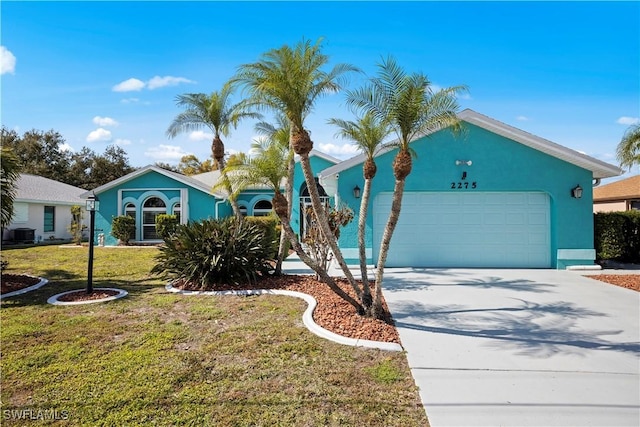 single story home with an attached garage, stucco siding, driveway, and a front yard