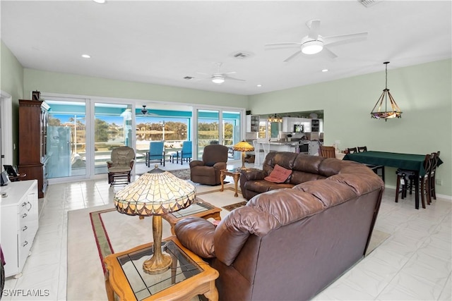 living room featuring baseboards, a ceiling fan, and recessed lighting