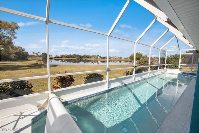 view of swimming pool featuring glass enclosure, a water view, a pool with connected hot tub, and a lawn