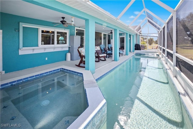 outdoor pool featuring a lanai, ceiling fan, a patio, and an in ground hot tub