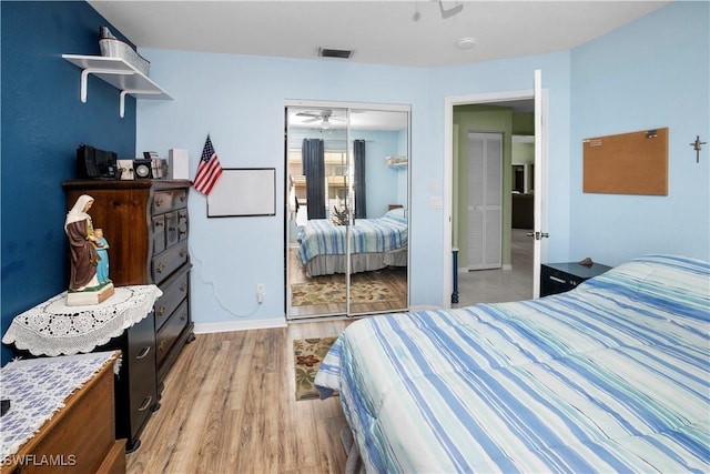 bedroom featuring a closet, light wood-type flooring, visible vents, and baseboards