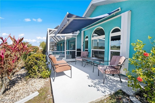 view of patio / terrace featuring glass enclosure