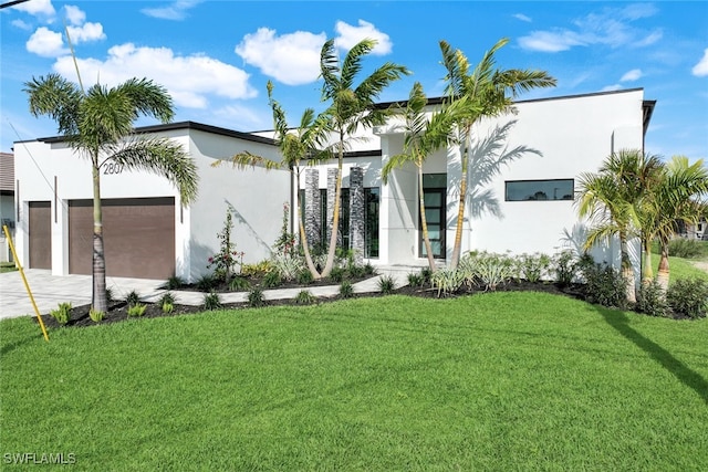 modern home with driveway, a front lawn, an attached garage, and stucco siding