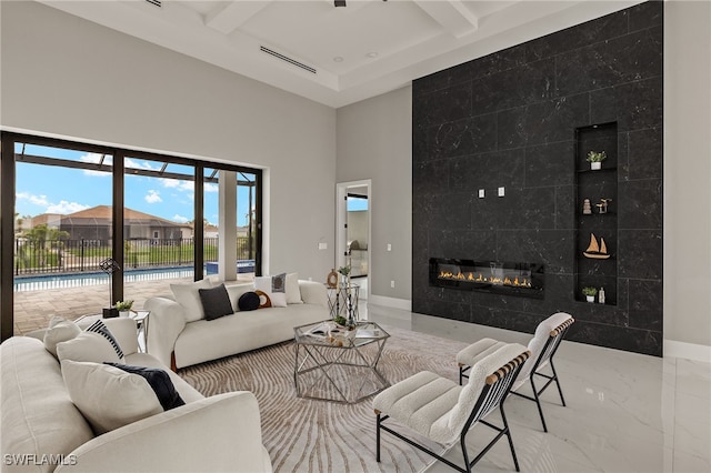 living area with visible vents, baseboards, marble finish floor, a fireplace, and beam ceiling