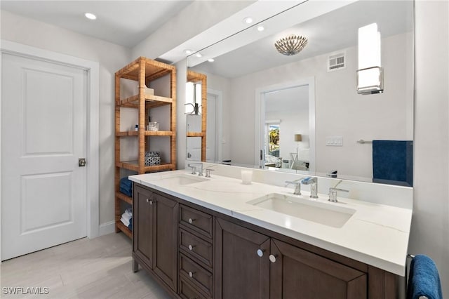 880 Huron Ct Unit 107, Marco Island, FL 34145 - bathroom featuring double vanity, ensuite bath, recessed lighting, and wood finished floors