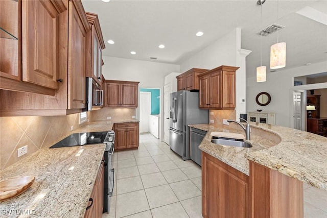 kitchen with stainless steel appliances, brown cabinetry, a sink, and visible vents