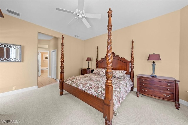 bedroom with connected bathroom, light colored carpet, a ceiling fan, baseboards, and visible vents